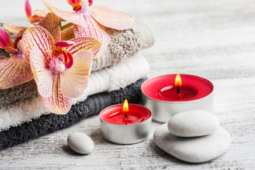 Spa still life with lit candles and red orange orchid