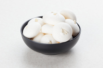 Fototapeta na wymiar White Meringue on a black plate. Smooth meringues with peanuts.