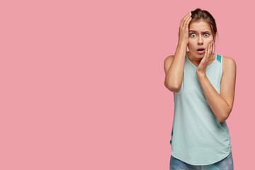 Stupefied terrific sportswoman keeps hand on head, stares with bugged eyes, cant believe in awful...