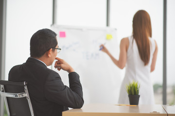 Successful business young woman presenting to employees, business coach giving presentation to clients in meeting room, team leader reporting about work explaining result on whiteboard