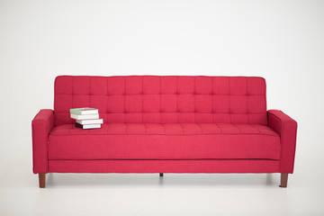 some book stay on a red sofa, on white background