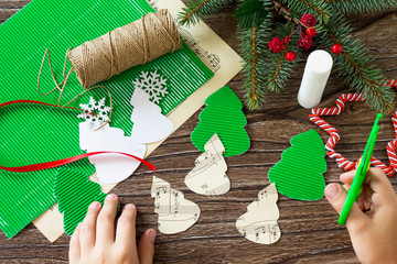 The child cuts out the details Christmas toy fir-tree. Handmade. Project of children's creativity,...