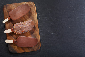  ice cream bar covered with chocolate on wooden board