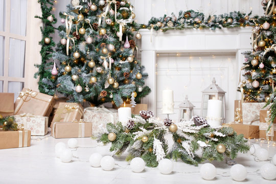 Christmas decor. Christmas tree decorations and holiday homes. New Year's interior with a fir tree in white tones