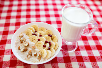 Oatmeal with milk, banana, berries and nuts. Healthy breakfast.