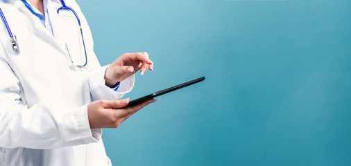 Medical doctor with digital tablet on a blue background