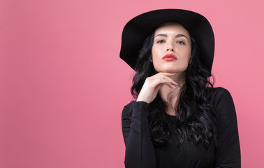 Beautiful young woman in a fashionable coat on a pink background