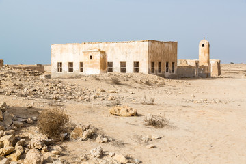 Ruined ancient old Arab pearling and fishing town Al Jumail, Qatar. Abandoned mosque with minaret. Deserted village. Pile of stones.