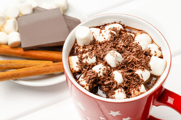 Cocoa in a red mug with marshmallows on a wooden table