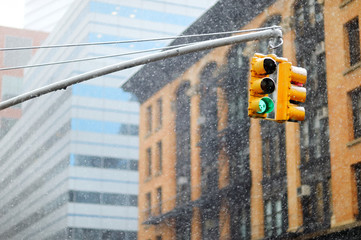 New York city traffic lights with skyscrapers on background during massive snowfall