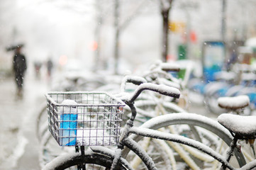 Row of old bicycles covered with snow after massive snowfall in New York City at wintertime.