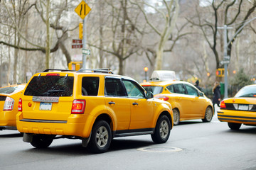 Yellow taxi cabs and people rushing on busy streets of downtown Manhattan.