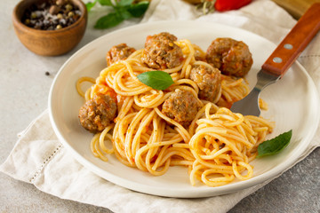 Italian style pasta dinner. Spaghetti with Meatballs with Tomato Sauce on stone or concrete table.