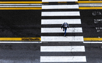 People crossing the street in a rainy day in Bologna, Italy