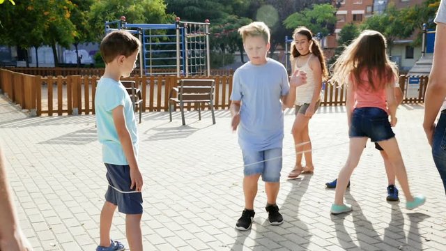 Girl jumping while jump rope game with friends outdoor