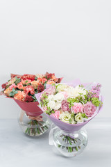 European floral shop. Two Bouquet Mixed beautiful flowers on wooden gray table. Nice garden flowers in the arrangement , the work of a professional florist.