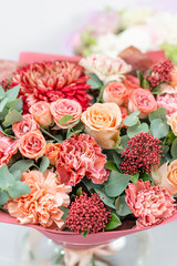 European floral shop. Bouquet Mixed beautiful flowers on wooden gray table. Nice garden flowers in the arrangement , the work of a professional florist.