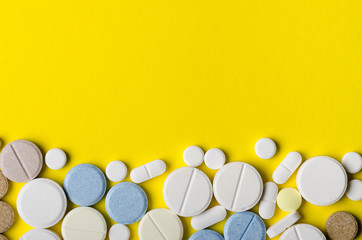 different pills on a yellow background from the bottom of the frame