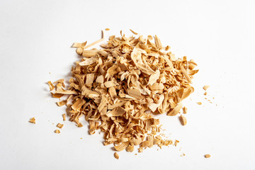 Natural wooden shavings created during home carving, isolated on white background