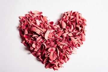 Fototapeta na wymiar Wooden shavings red heart shape isolated on white background