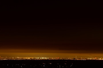 Fototapeta premium View from the hill on a slender night city at the foot
