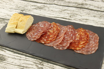 Charcuterie et tranches de pain sur une ardoise