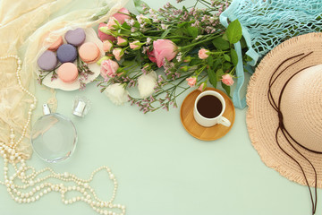 fresh vintage perfume bottle next to aromatic flowers on wooden table