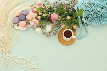 plate of macaroons over wooden table cofee and flowers.