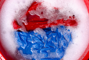 Washing color clothes in basin enemale powdered detergent, top view