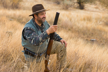 Hunter with a hat and a gun in search of prey in the steppe