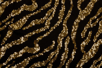 Fototapeta na wymiar Black fabric with golden sequin pattern
