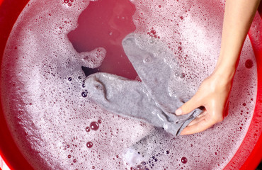 Women washing socks clothes in basin enemale powdered detergent, top view