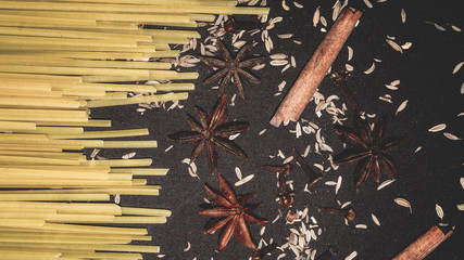 fettuccine pasta stick and the spices; cinnamon stick, star anise, cloves , cumin. food and culinary background