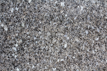 Texture dark granite. Smooth sparkle stone texture. Uniform surface with stone grinding. Dark gray stone with inclusions. Material for decoration, background texture, interior design.