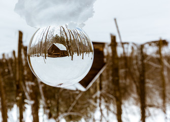 Crstal ball showing a Sugar shack and old barn in a boreal forest Quebec, Canada.