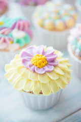 Many sweet birthday cupcakes with flowers and butter cream