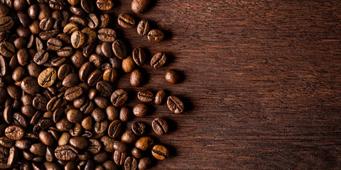 fresh roasted coffee beans on natural dark oak wood panorama wide wooden closeup macro background