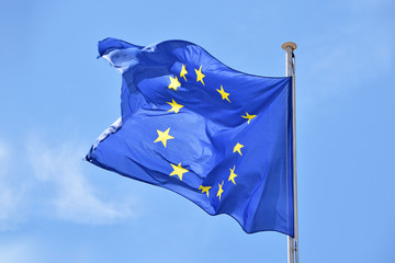 Close up flag of EU waving in wind over blue sky