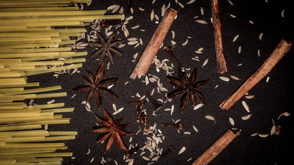 fettuccine pasta stick and the spices; cinnamon stick, star anise, cloves , cumin. food and culinary background