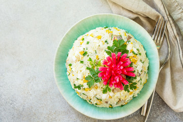 Festive Salad with Rice, Onion, Egg, Corn and Mushrooms on a gray stone or concrete table. Top view flat lay background. Copy space.