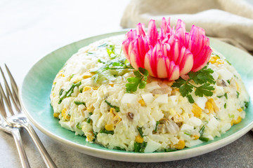 Festive Salad with Rice, Onion, Egg, Corn and Mushrooms on a gray stone or concrete table.