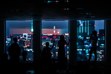 都会の夜景と人々のシルエット