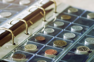 Coin collecting. Close-up view of coins holding in blisters in coin album. Numismatics