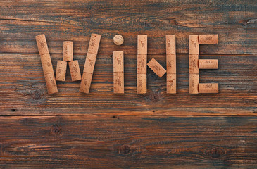 Fototapeta premium Word wine shaped by corks over dark vintage wood