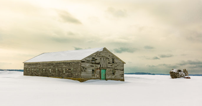 Antique barn in rural Quebec Canada after a snow storm.