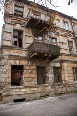 Fototapeta na wymiar Ruins of an old abandoned city. Ruined house in which poor people live. Odessa, the ruins of a historic residential building. The ruins of an old earthquake-hit house. Lost city.