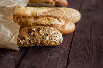baguettes in paper bags on wooden table, top view. Copy space.