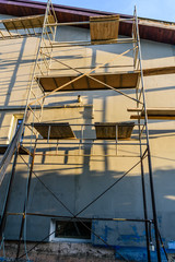 Naklejka premium Insulation of the house with styrofoam. Scaffold on building