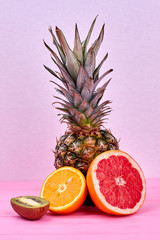 Composition from exotic fruits on colorful background. Fruits rich with vitamin C on pink background.
