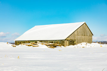 Antique barn in rural Quebec Canada after a snow storm.